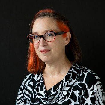 Femme souriante devant un fond noir